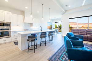 Kitchen with open floor plan, stainless steel appliances, a mountain view, and white cabinetry