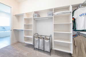 Walk in closet featuring light carpet