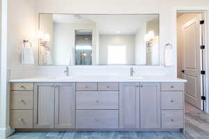 Full bathroom with double vanity and a stall shower