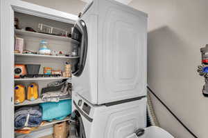 Laundry room with stacked washing machine and dryer