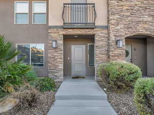Entrance to property with stone siding and stucco siding