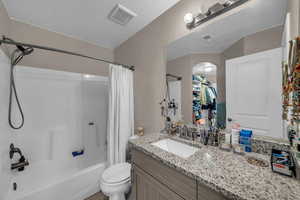 Bathroom featuring vanity and shower / bath combination with curtain