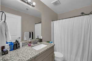 Full bath featuring vanity, a shower with curtain, and a textured ceiling