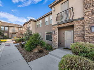 Entrance to property featuring stucco siding and stone siding