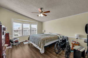 Bedroom featuring dark wood-style flooring, a ceiling fan, and ornamental molding
