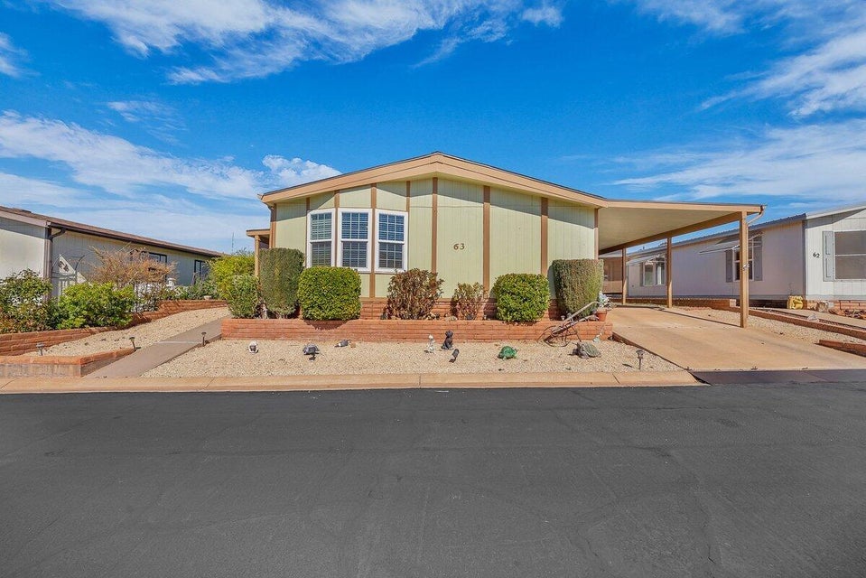 Manufactured / mobile home featuring an attached carport and concrete driveway