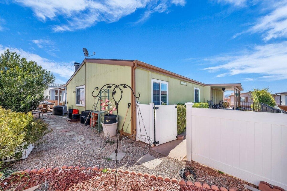 View of property exterior with a patio and a gate