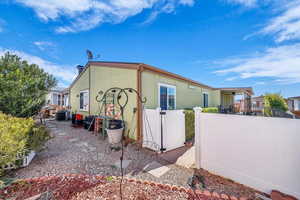 View of property exterior with a patio and a gate