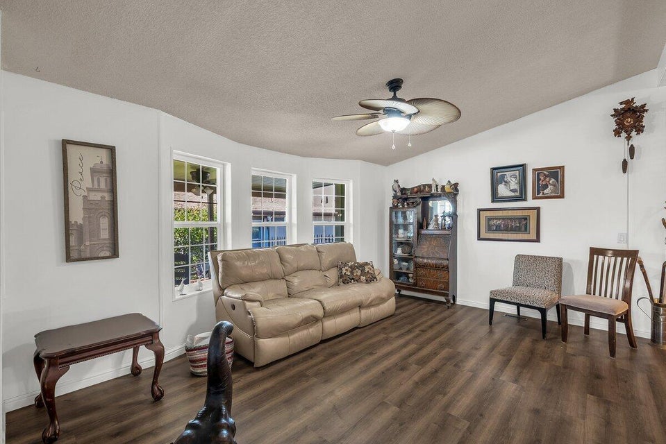 Living area with ceiling fan and wood finished floors