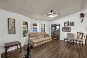 Living area with ceiling fan and wood finished floors