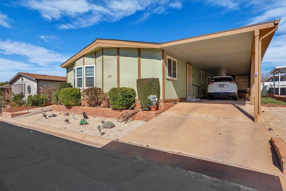 Manufactured / mobile home featuring a carport and driveway