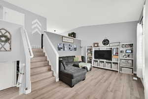 Living area featuring stairs and light wood-style flooring