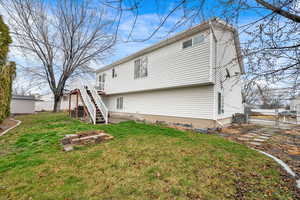 Back of property with a deck, a gate, and an outbuilding