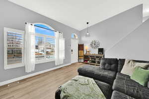 Living area featuring light wood finished floors and vaulted ceiling