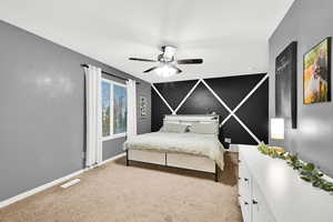 Bedroom featuring light carpet, ceiling fan, and an accent wall
