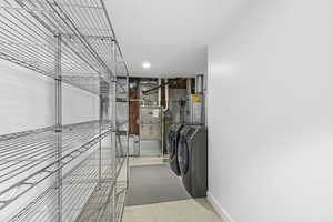 Laundry area with washer and clothes dryer, gas water heater, and heating unit