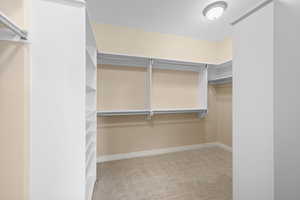 Walk in closet featuring light colored carpet
