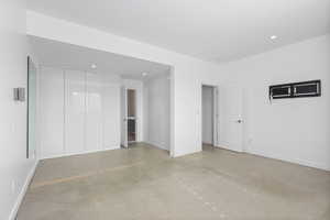 Unfurnished bedroom featuring concrete floors, a closet, and recessed lighting