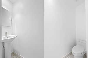 Bathroom featuring baseboards and toilet