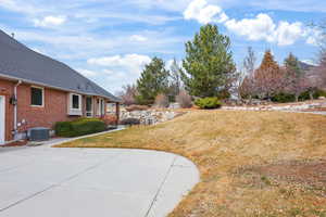 View of grassy yard featuring a patio area