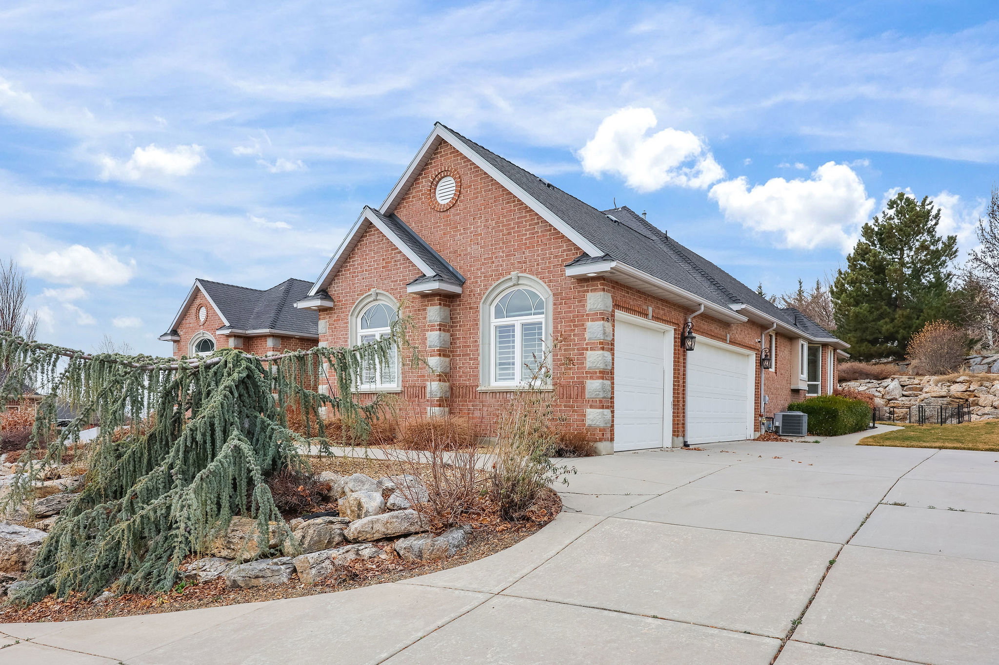Ranch-style house with brick siding, an attached garage, driveway, and a shingled roof