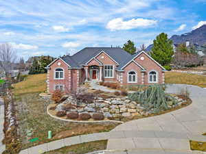 View of front of house with brick siding, a front lawn, and a mountain view