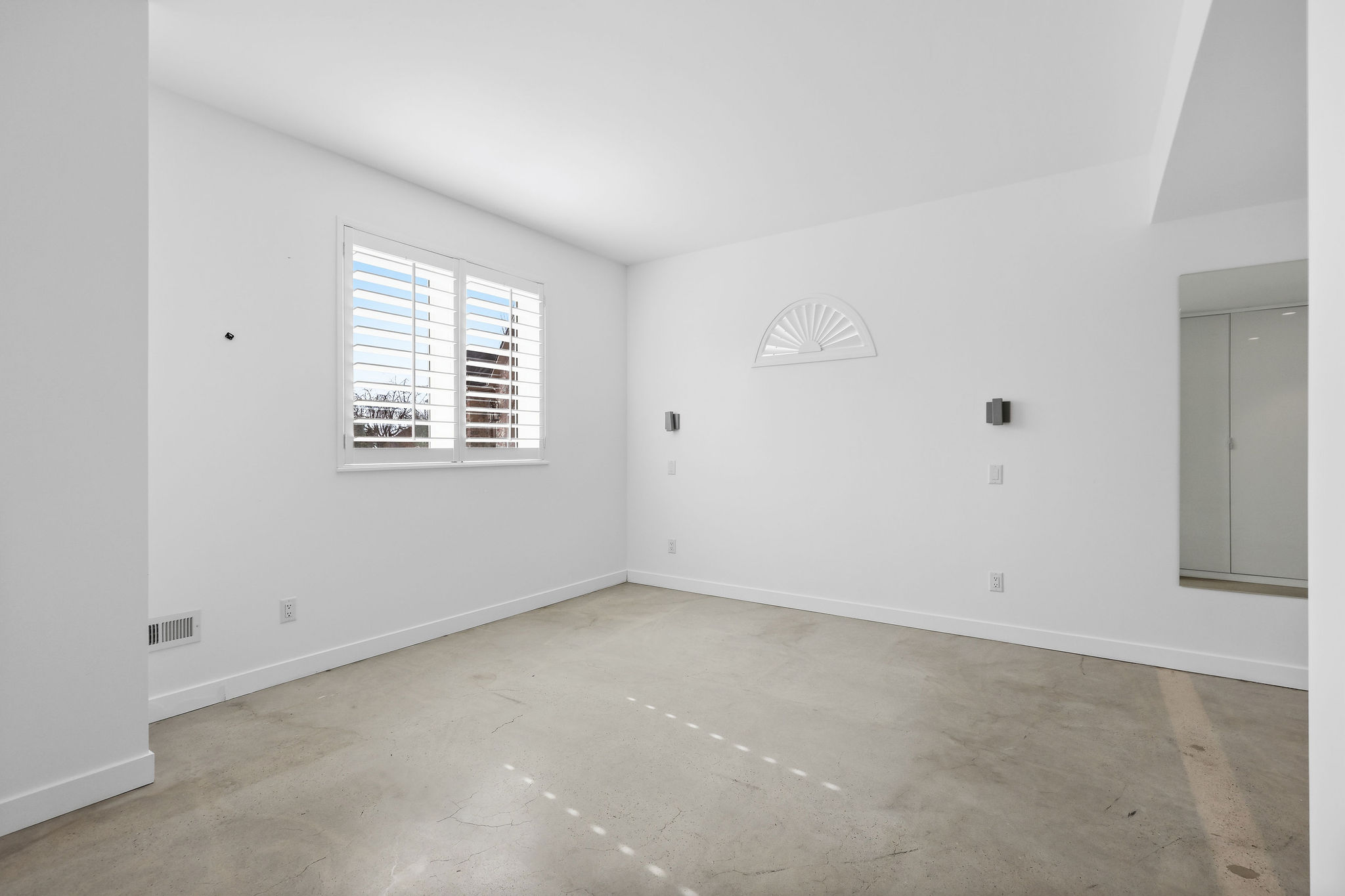 Spare room with concrete flooring and baseboards