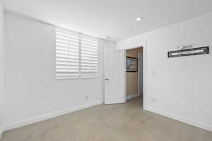 Unfurnished bedroom with finished concrete flooring and recessed lighting