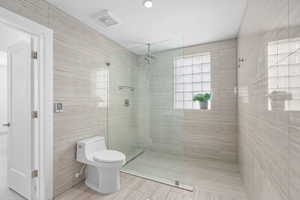 Full bath featuring a walk in shower and tile walls