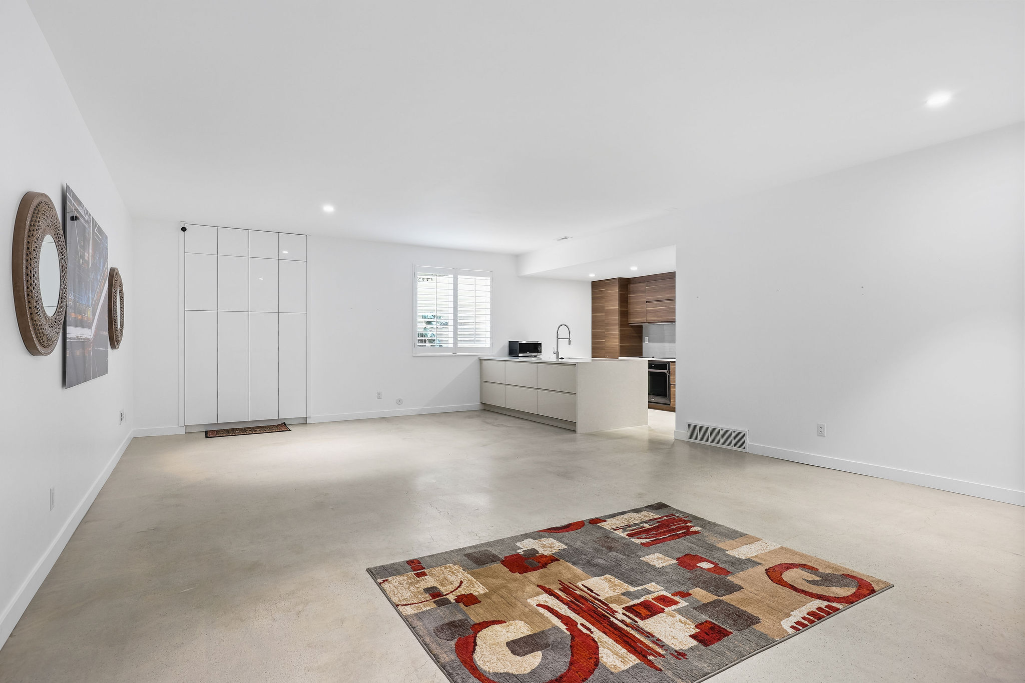 Unfurnished living room featuring finished concrete flooring and recessed lighting