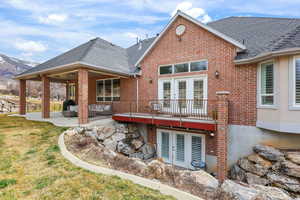Back of house featuring french doors, a patio, brick siding, a shingled roof, and a yard