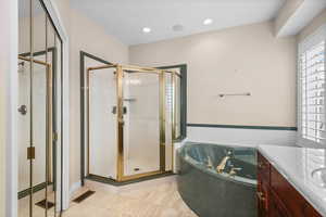 Full bathroom featuring a shower stall, a bath, vanity, light tile patterned floors, and recessed lighting