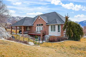 Rear view of house featuring a mountain view, brick siding, french doors, a patio, and roof with shingles