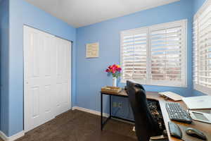 Bedroom featuring dark colored carpet and baseboards