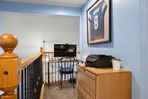 Loft with office featuring light colored carpet