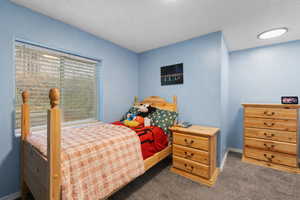 Carpeted bedroom with baseboards and a textured ceiling