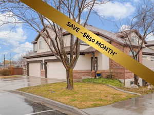 View of property with a garage and concrete driveway