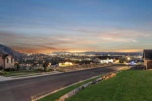 View of asphalt street featuring a mountain view, curbs, and sidewalks