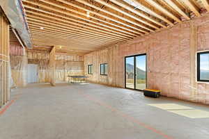 Miscellaneous room with unfinished concrete flooring and a mountain view