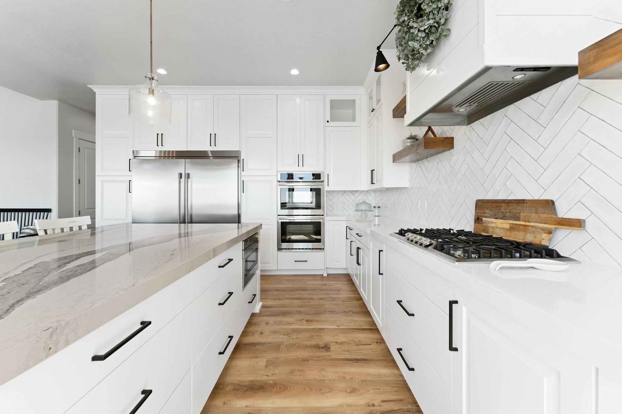 Extra large Kitchen with light stone countertops, built in appliances, white cabinetry, open shelves, and light wood-style floors, 6 foot wide refrig/freezer built-in