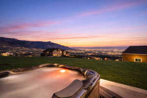 View of patio with a mountain view and a hot tub