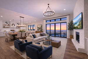 Living area with dark wood-type flooring, hanging lights, and a brick fireplace. Decor is a virtual decor concept.