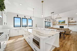 Kitchen featuring white cabinetry, light stone countertops, and a kitchen island