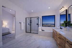 Bathroom featuring a shower stall, a bath, ensuite bathroom, vanity, and recessed lighting