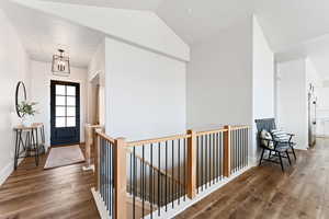 Entrance foyer with wood finished floors and vaulted ceiling