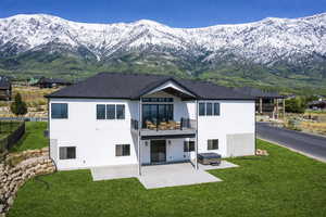 Rear view of property with a balcony, stucco siding, and a mountain view
