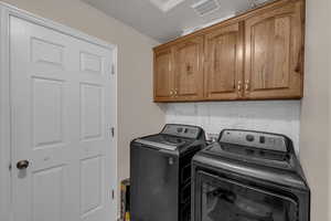 Laundry area featuring washer and dryer and cabinet space