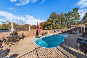 View of swimming pool with patio surround, a fenced backyard, and outdoor dining space