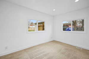 Empty room featuring light colored carpet and recessed lighting