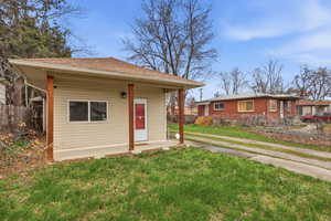 View of front of home with covered porch and roof with shingles